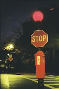 a red stop sign sitting on the side of a road