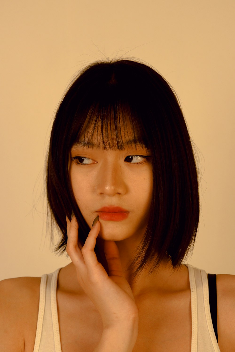 a woman with a short hair and a white tank top