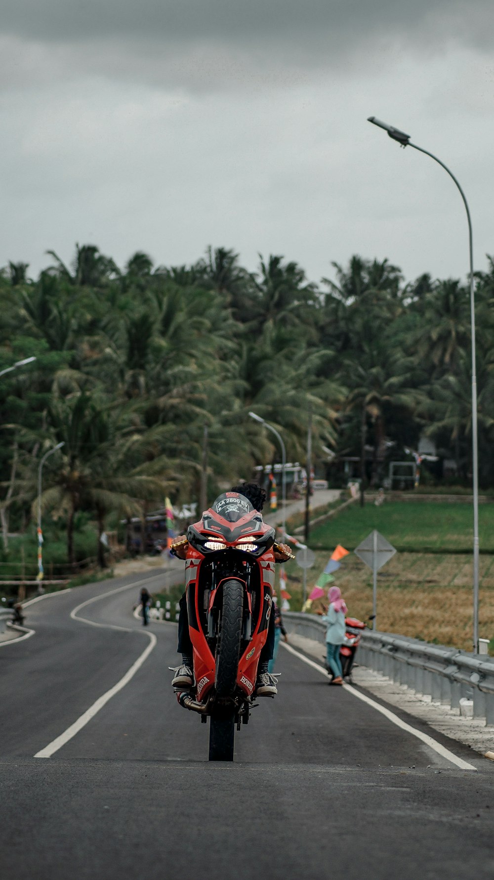 a person riding a red motorcycle down a street