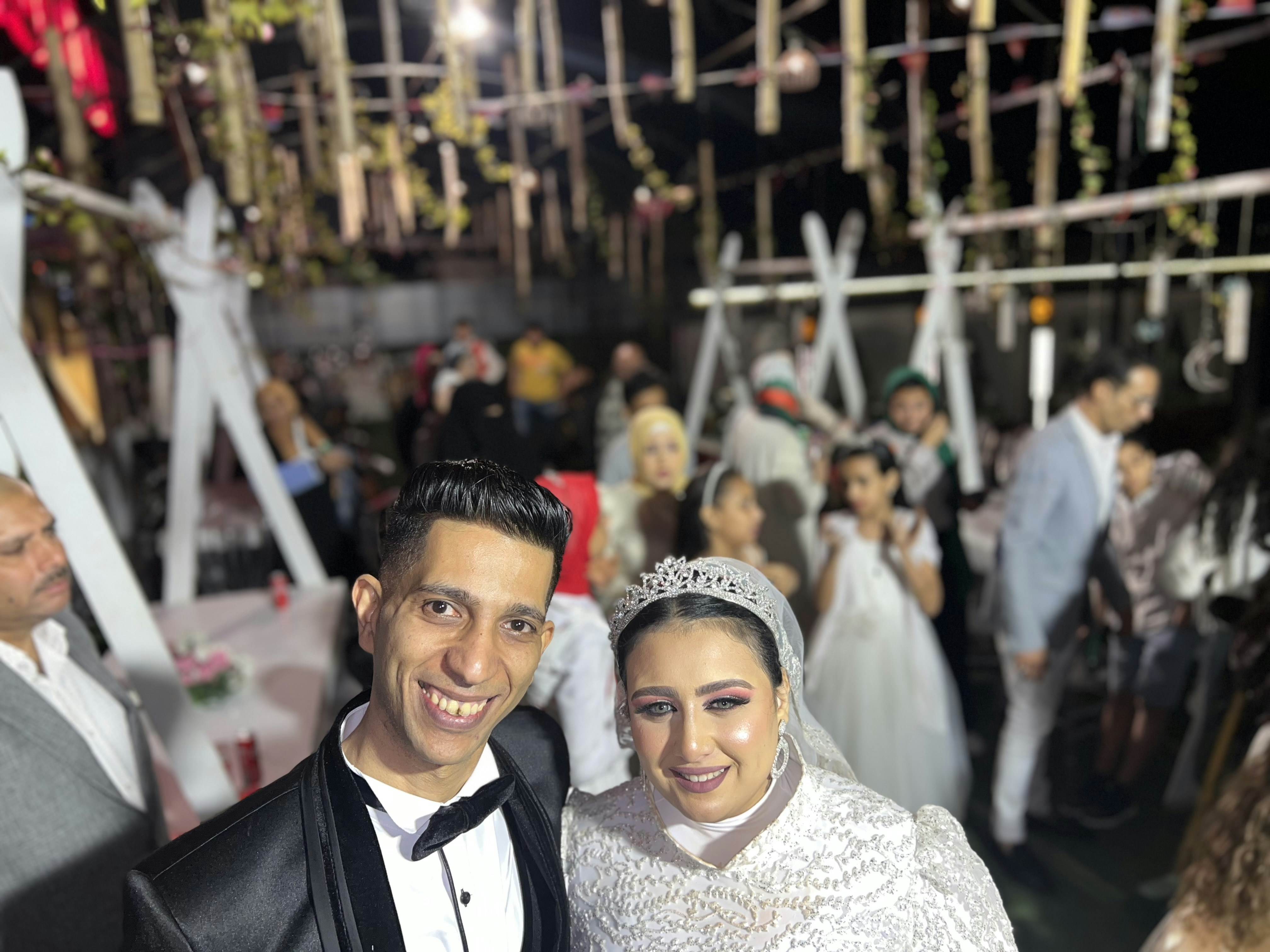 Happy couple at their wedding reception, smiling, elegant venue with warm lighting