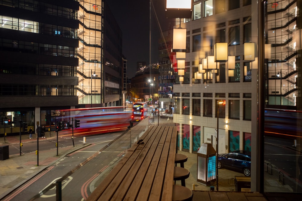 a city street at night with a train passing by