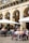 A sunny outdoor café patio filled with happy diners enjoying their meals.