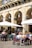 A sunny outdoor café patio filled with happy diners enjoying their meals.
