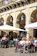 A cozy outdoor terrace filled with diners enjoying a sunny afternoon meal.