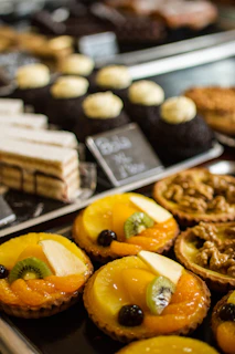 A vibrant display of colorful fruit tarts and wholesome pastries arranged beautifully on a natural linen cloth.