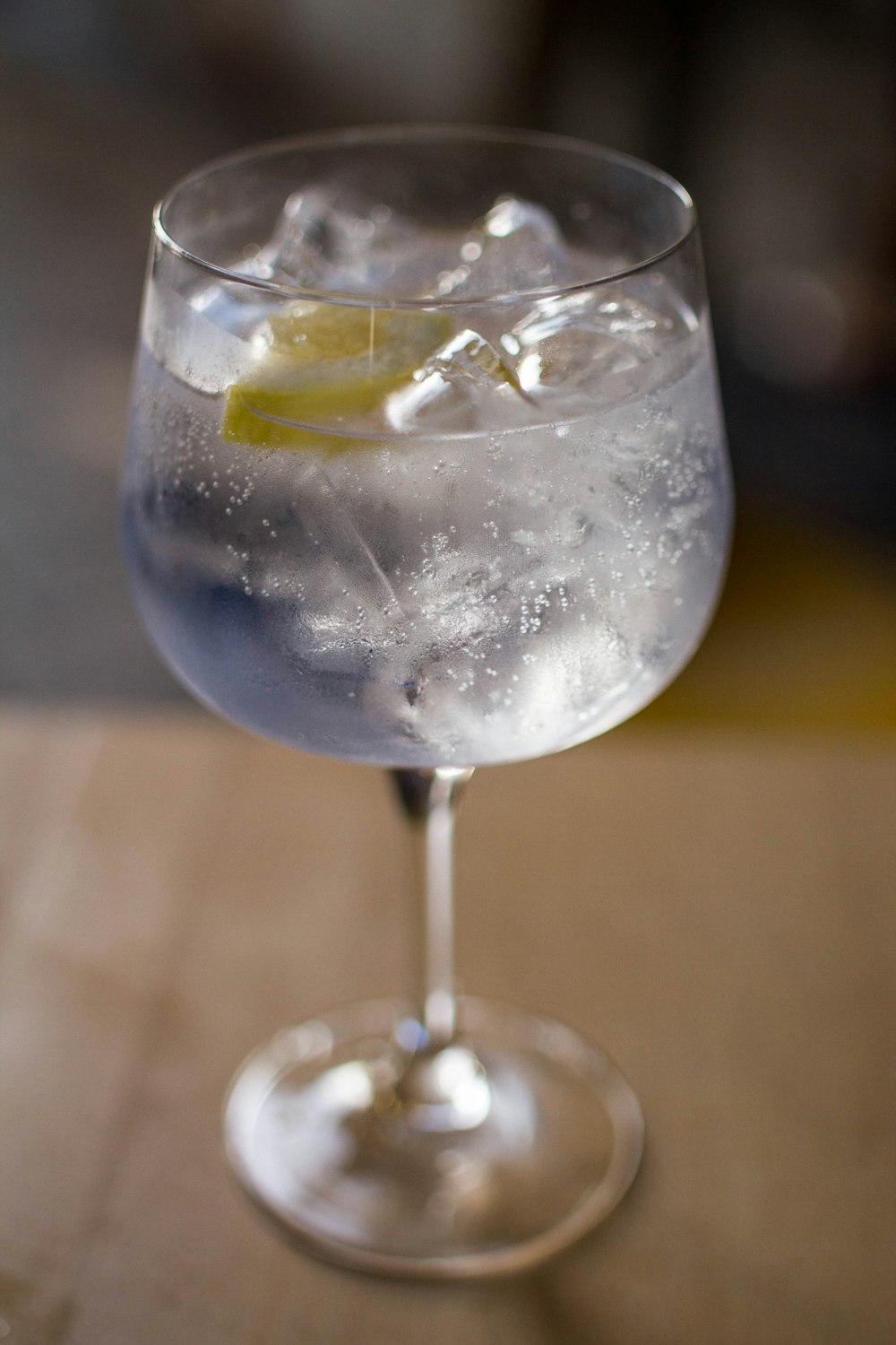 a glass filled with ice and a lemon wedge