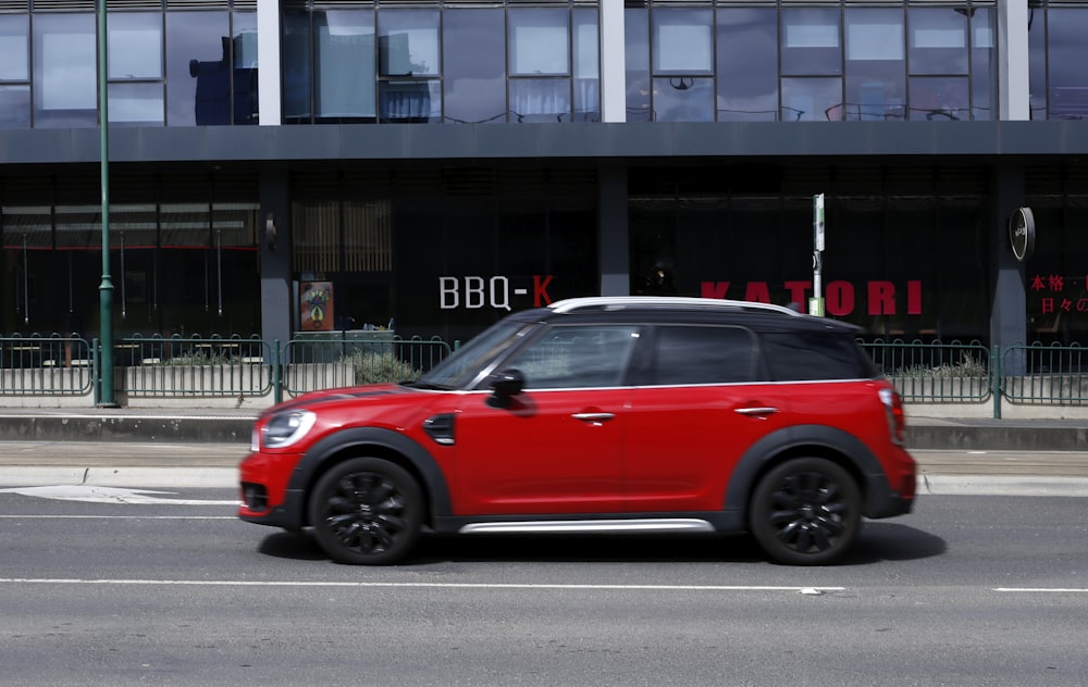 a red mini countryman parked in front of a building