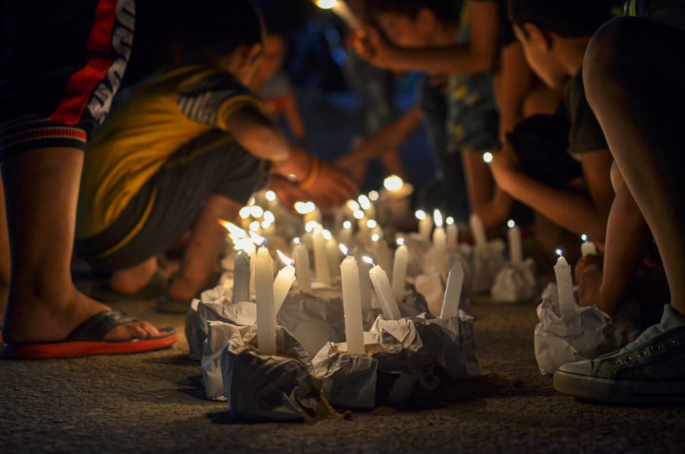 a group of people standing around a bunch of lit candles