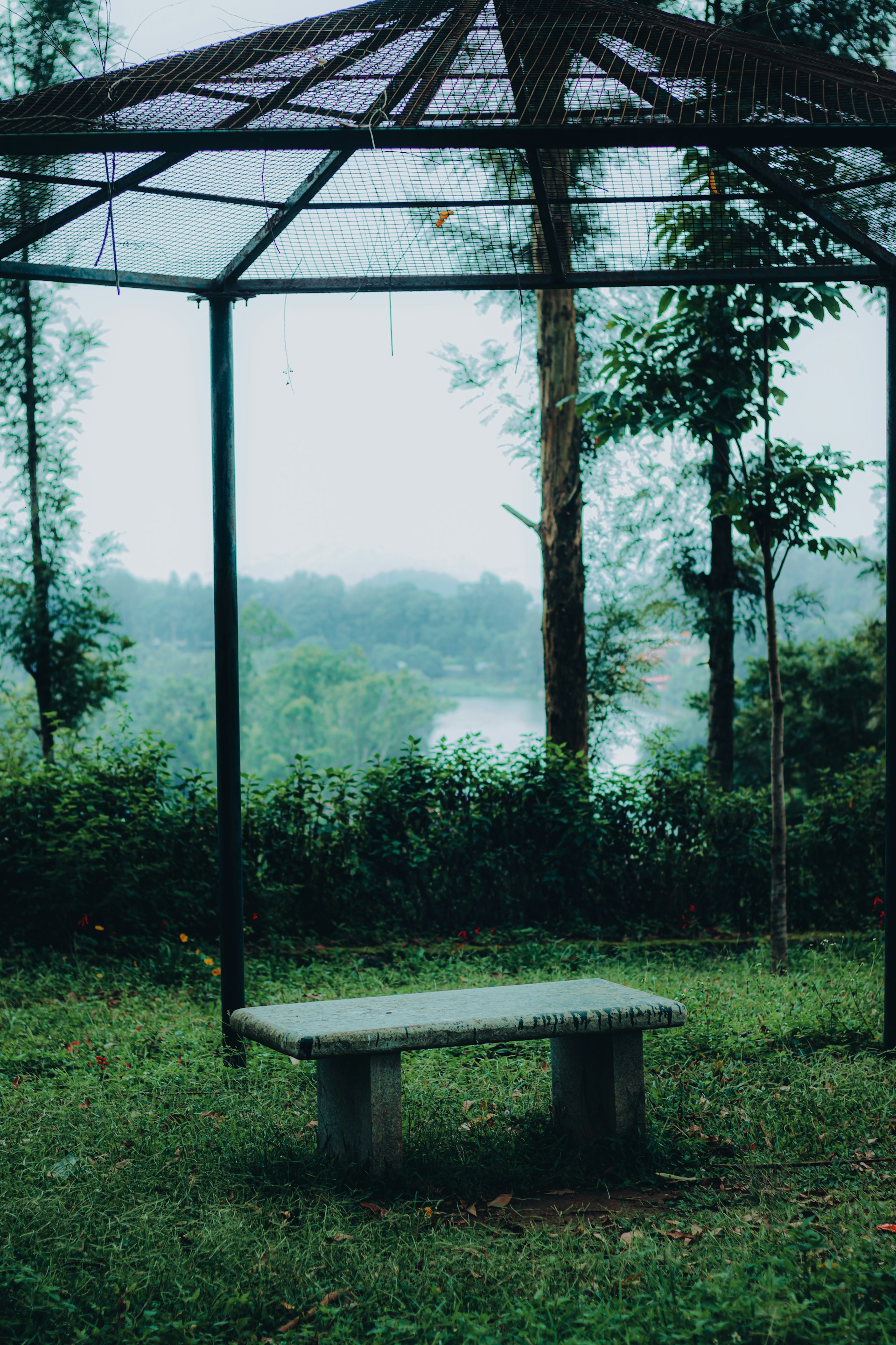 a wooden bench sitting under a canopy in a park