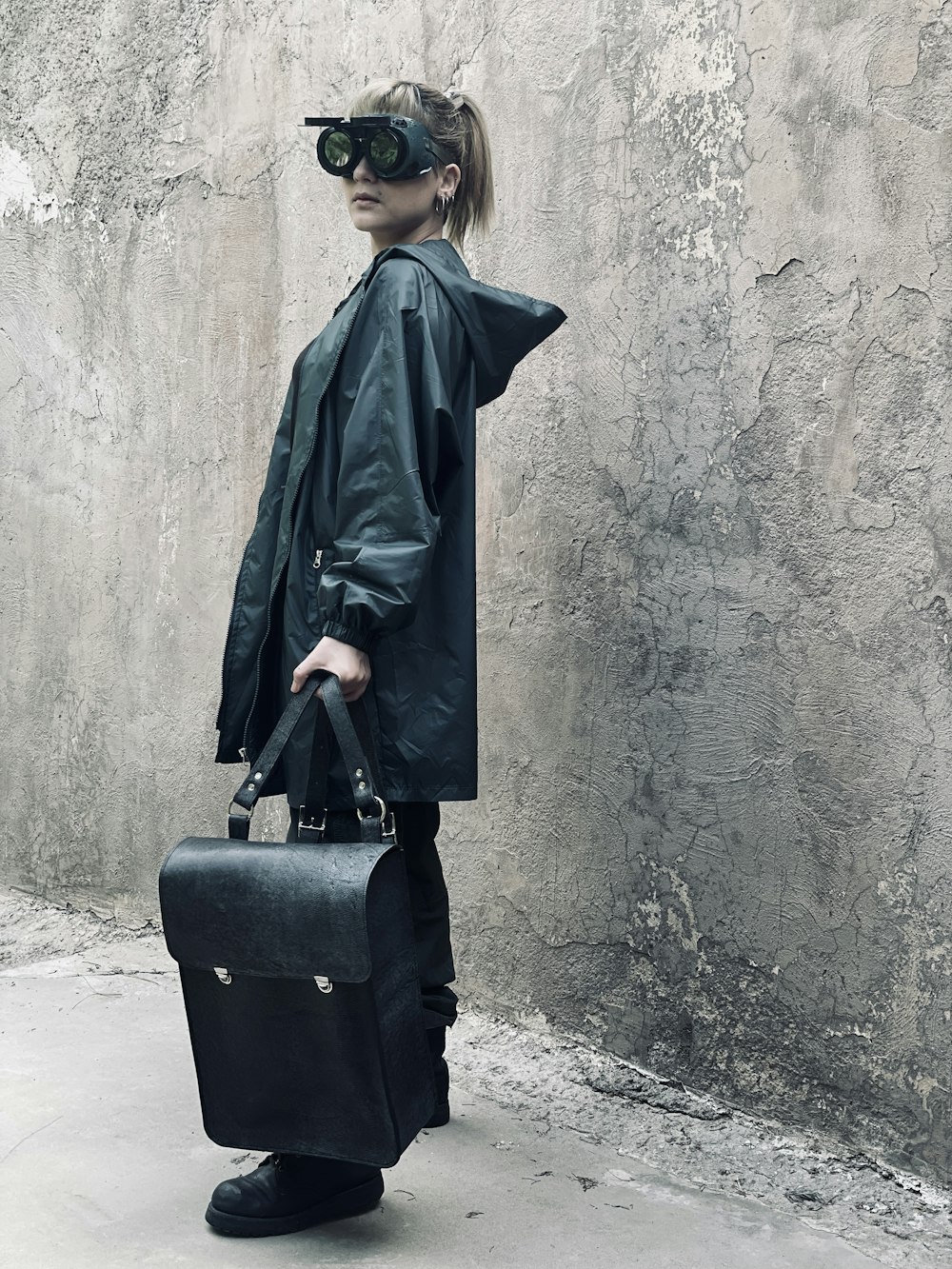 a woman holding a briefcase and wearing a leather jacket