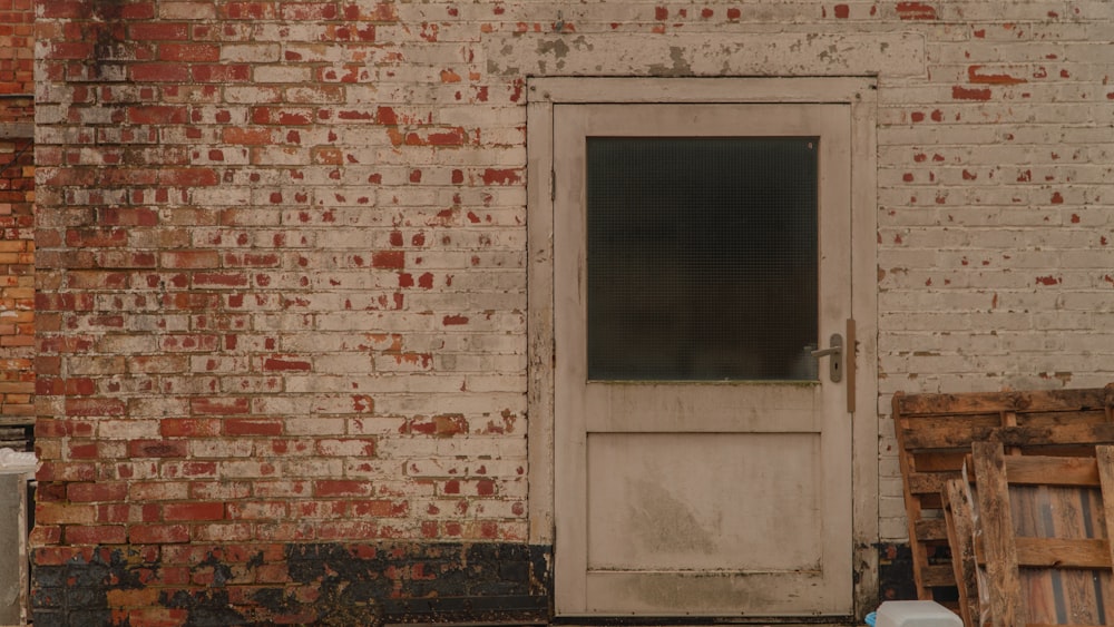 a white door sitting next to a brick building