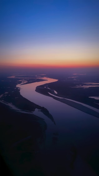 a river running through a lush green countryside