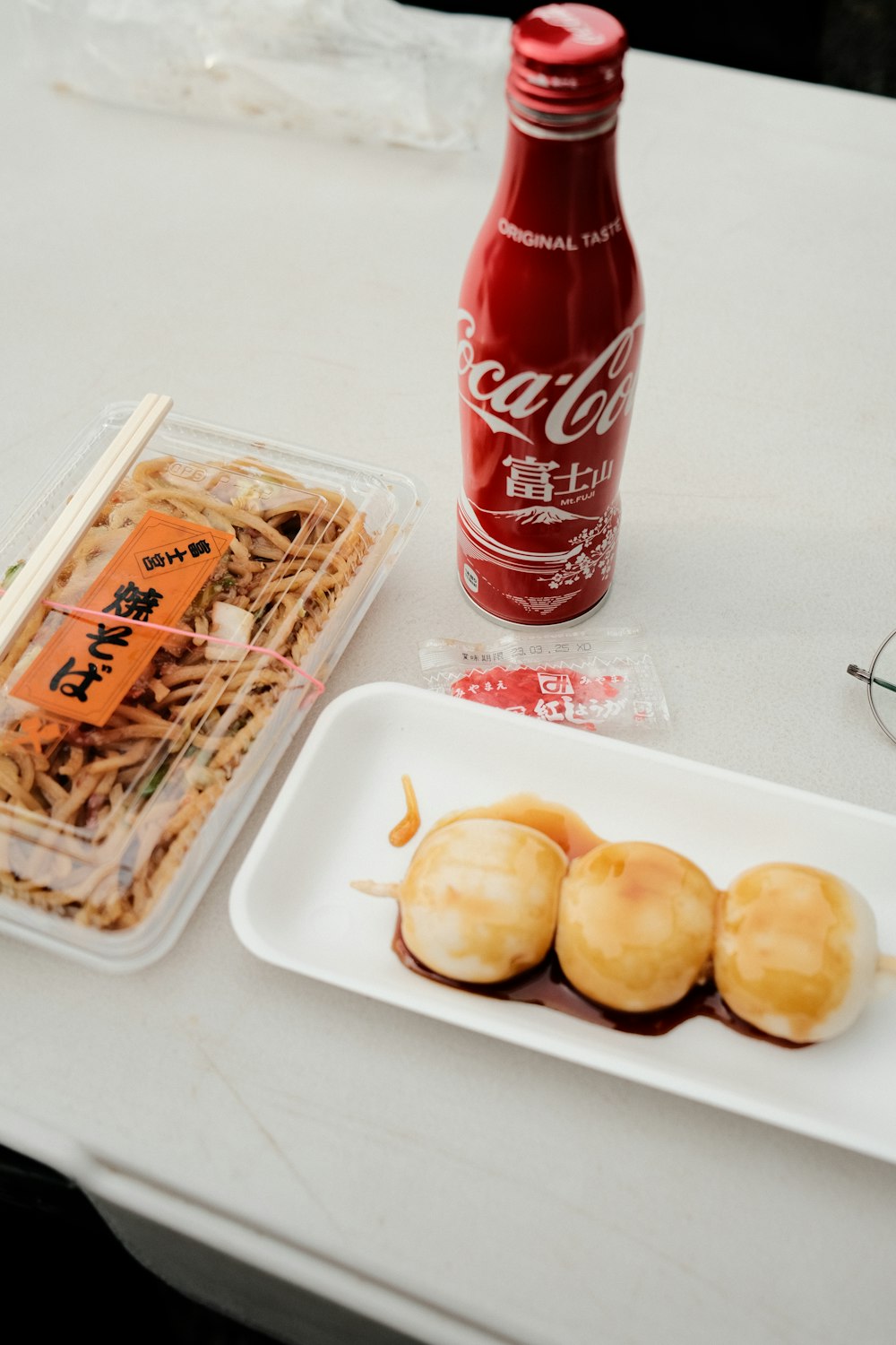 a bottle of coca cola and some food on a table