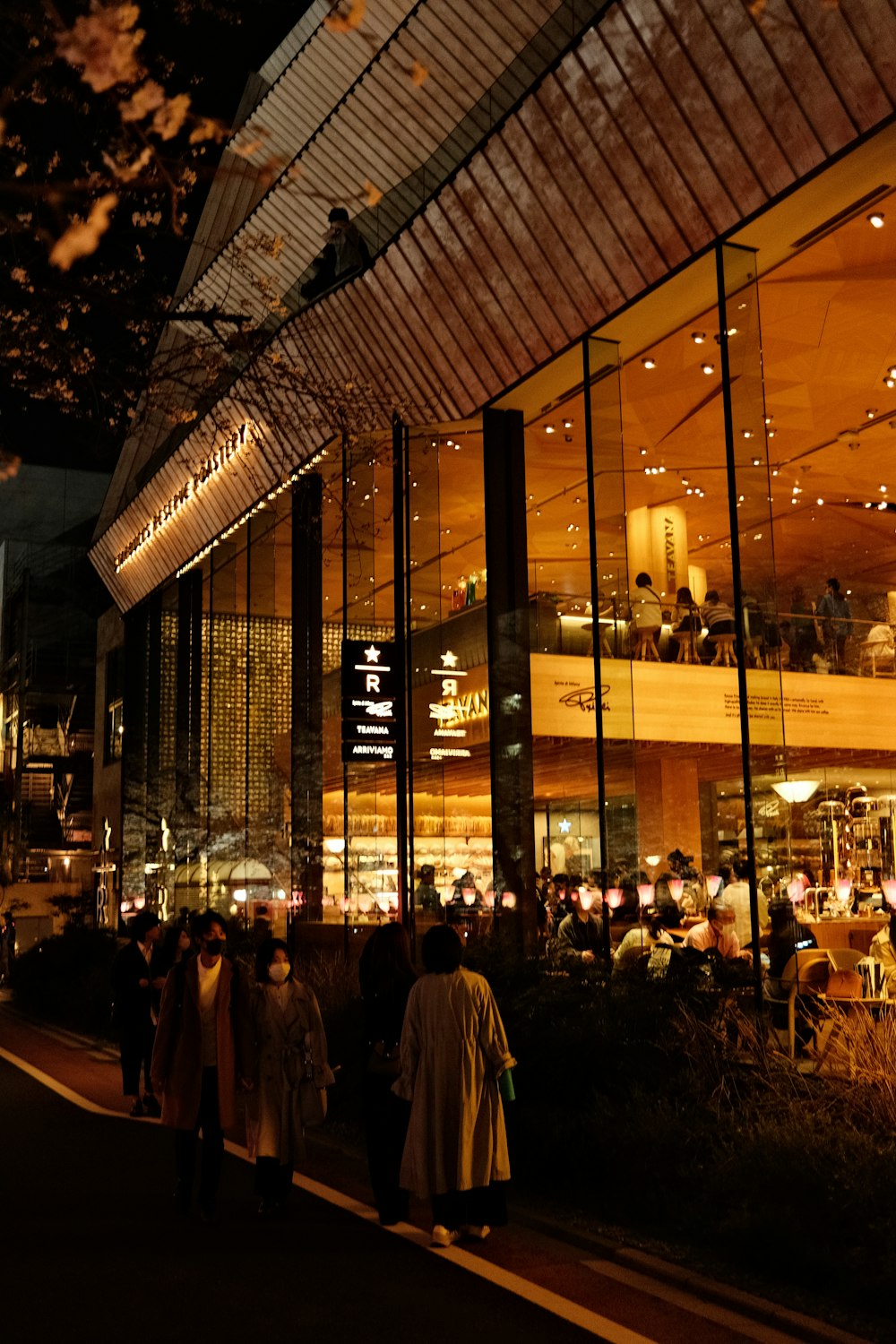 a group of people standing outside of a building at night