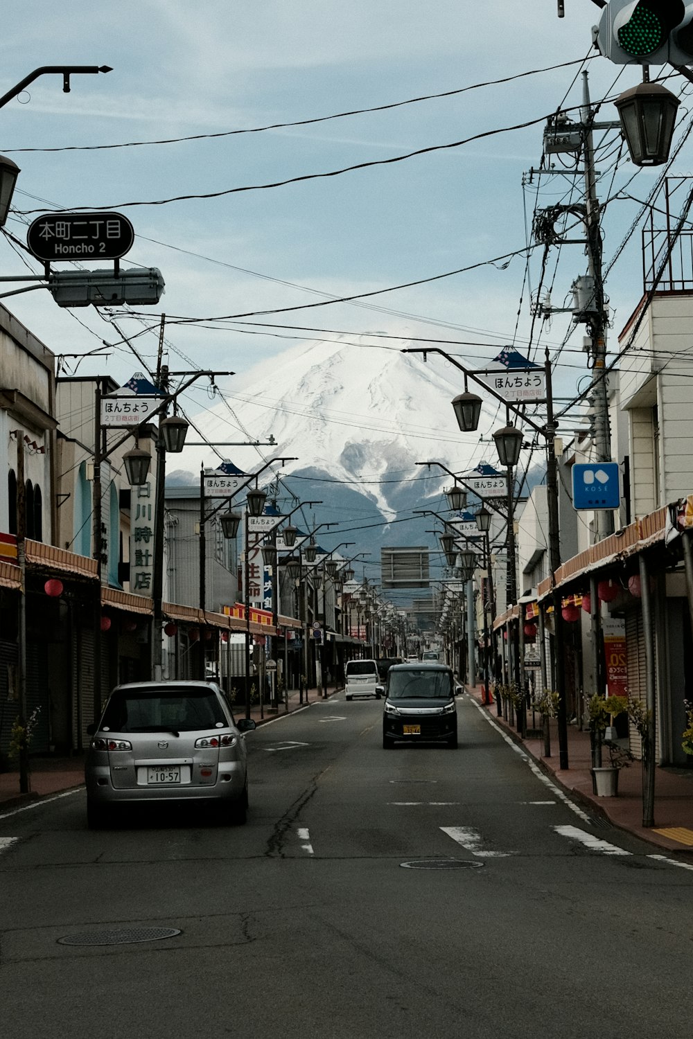 a car driving down a street with a mountain in the background