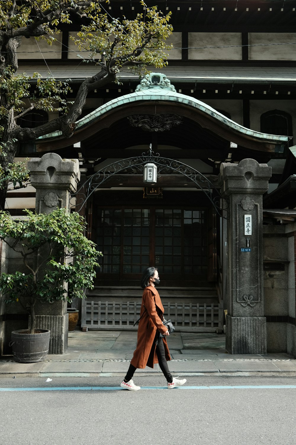 a woman walking across a street in front of a building