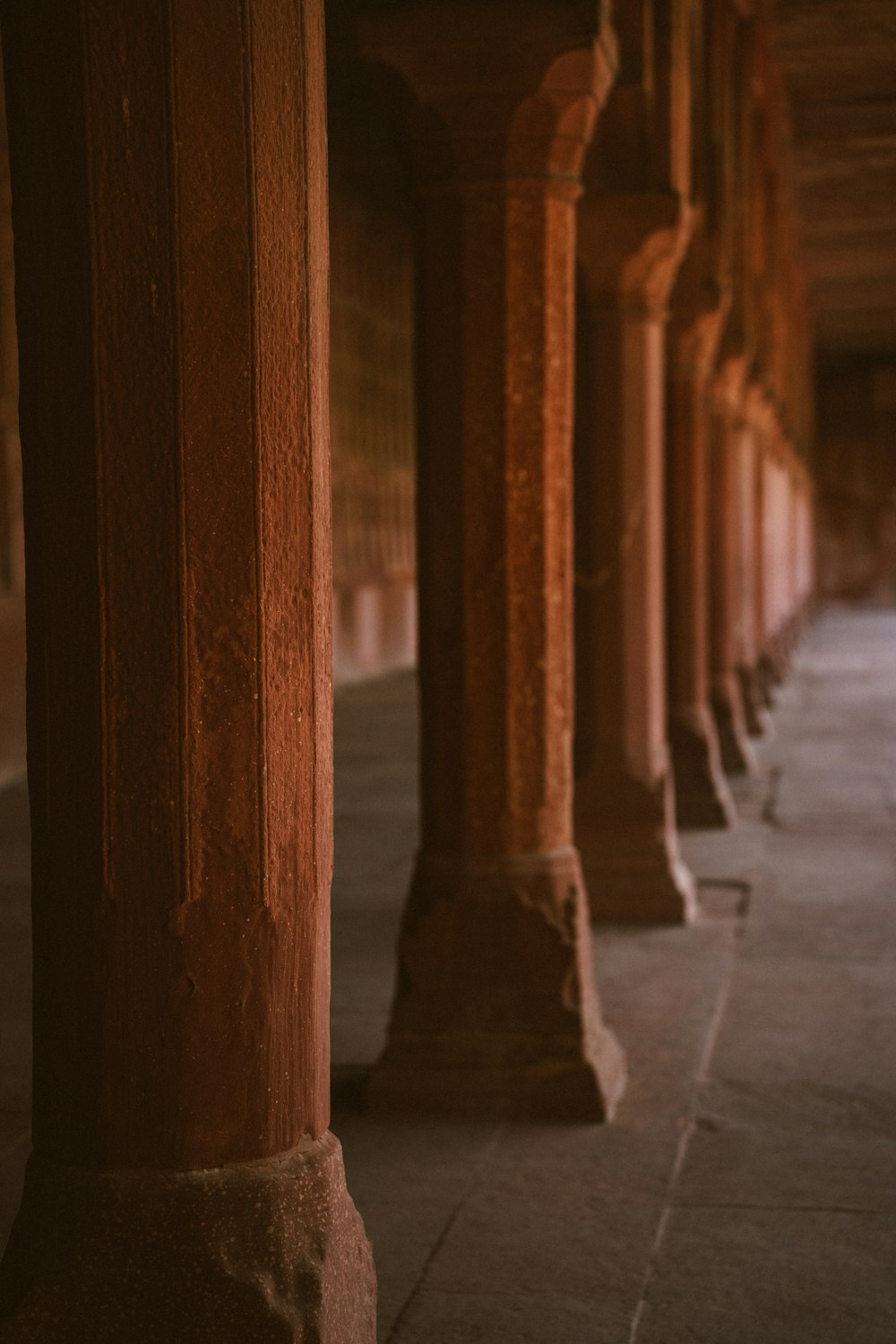 a row of pillars with a clock on top of it