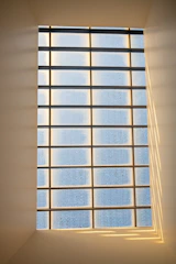 Frosted glass office partition with subtle geometric patterns, softly lit by natural daylight.