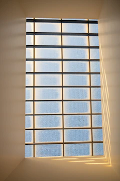 Frosted glass office partition with subtle geometric patterns, softly lit by natural daylight.