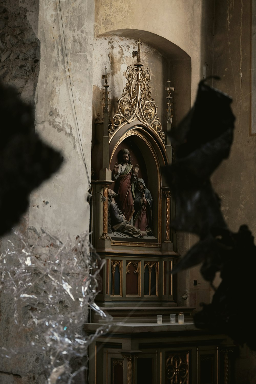 a statue of jesus in a church with broken glass