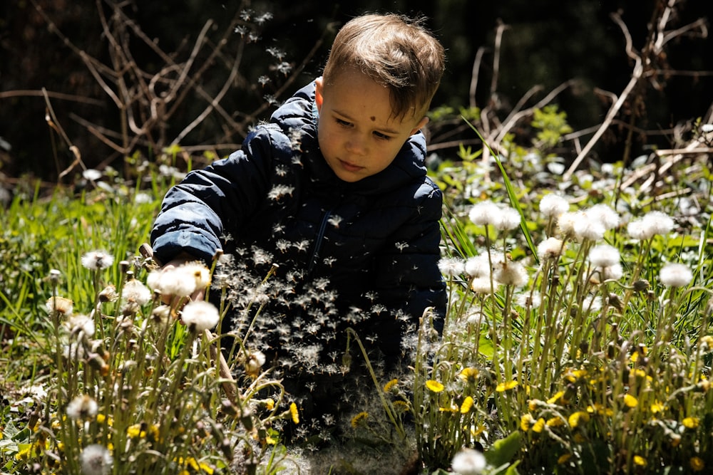 a young boy playing in a field of dandelions