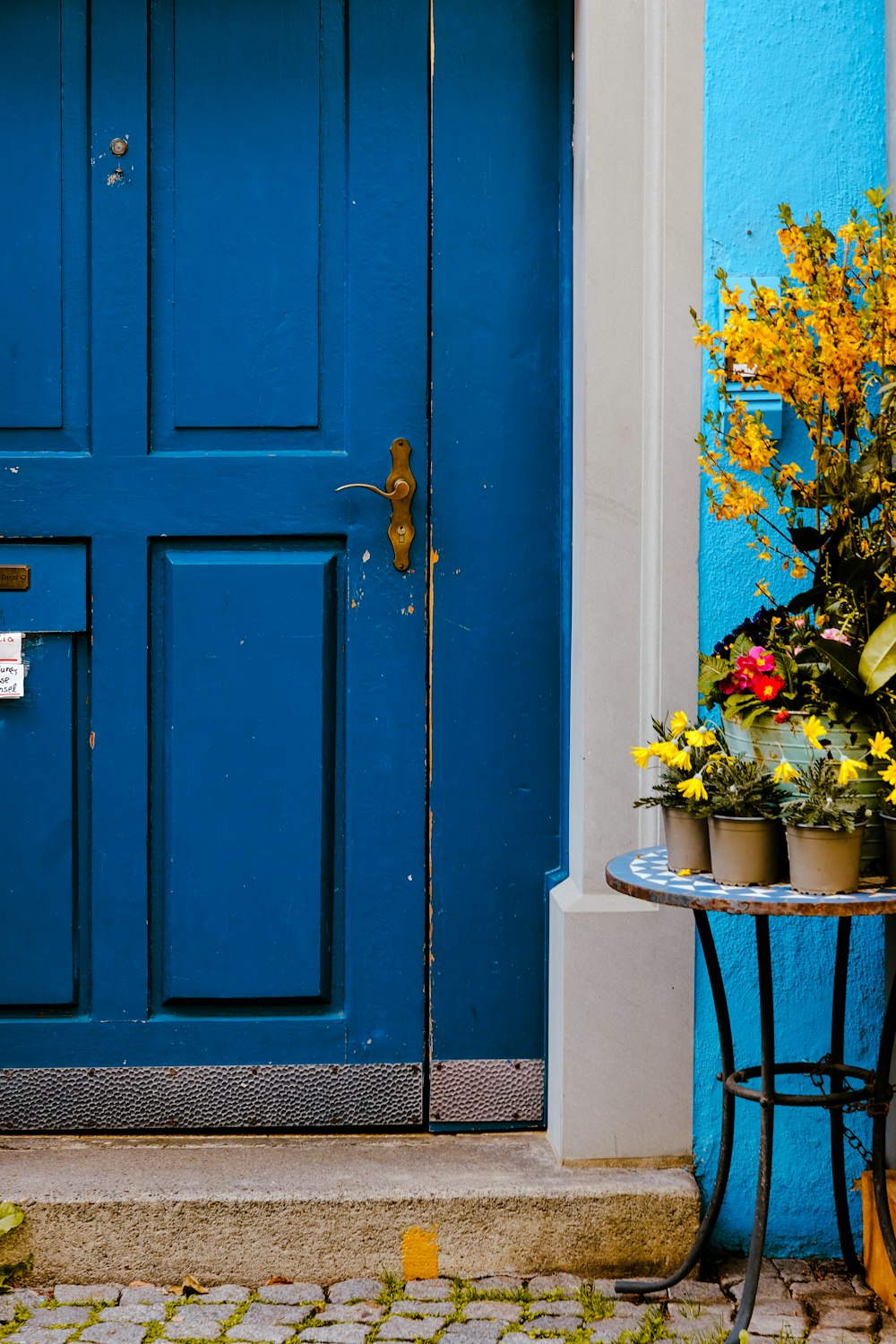 a blue door and a table with flowers on it