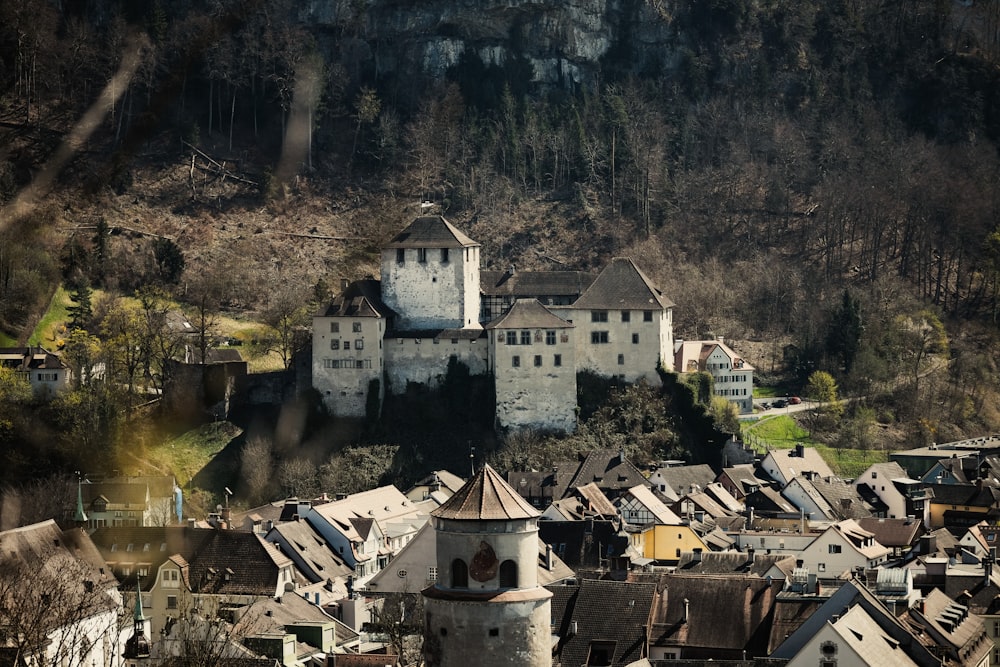 a large white castle sitting on top of a lush green hillside