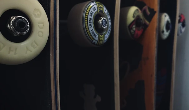Close-up of fresh skateboard decks stacked with vibrant graphics under bright light.
