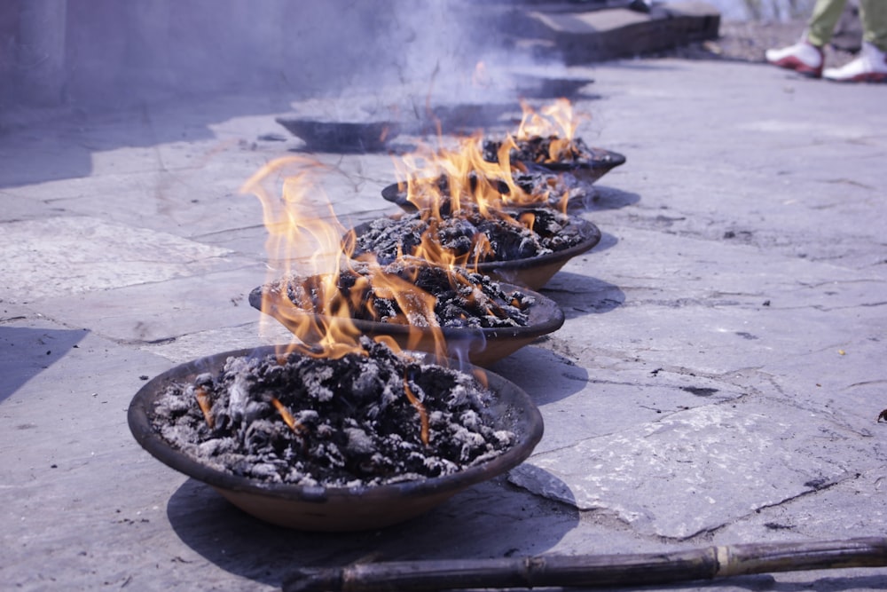 a row of fire bowls sitting on top of a sidewalk