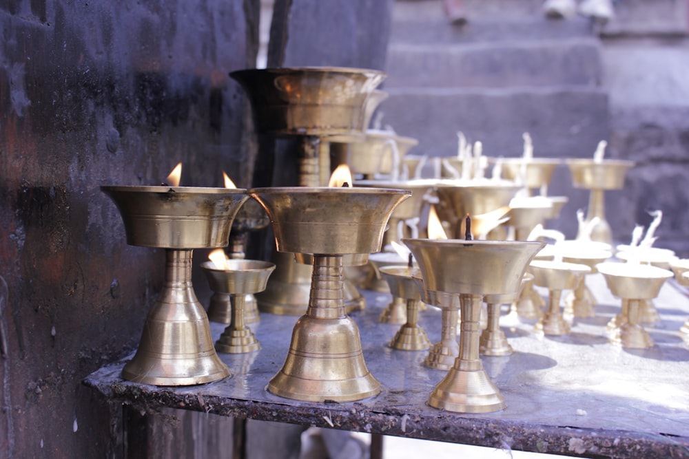 a group of brass candles sitting on top of a table