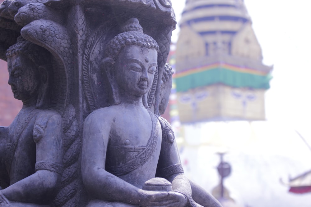 a statue of a person holding a bowl in front of a building