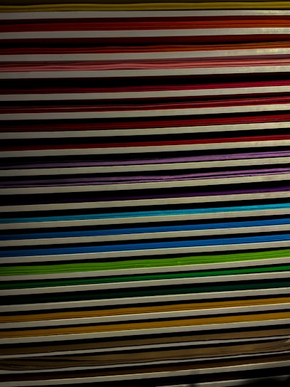 A stack of colorful assorted paper sheets neatly arranged on a wooden desk.