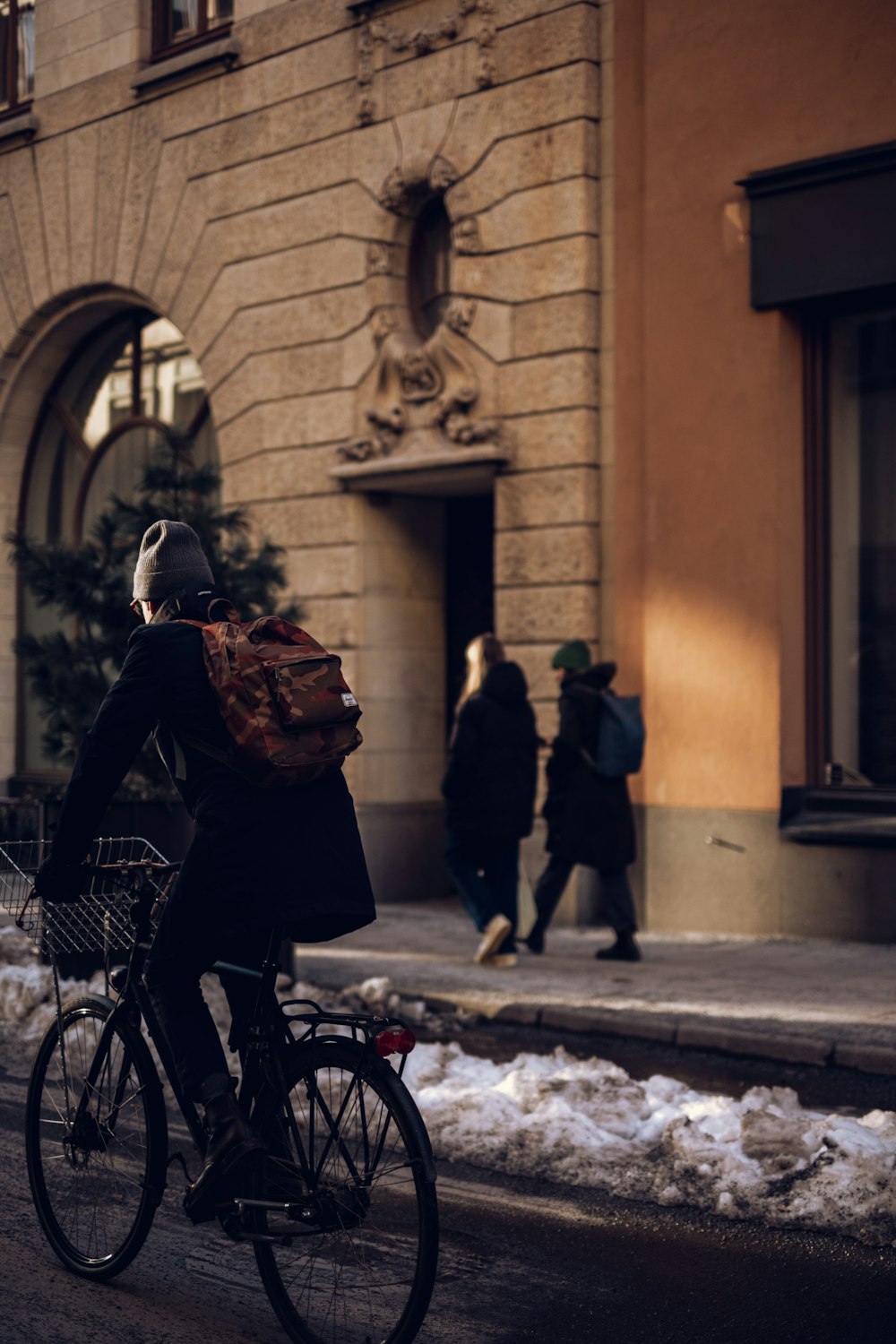 a man riding a bike down a snow covered street