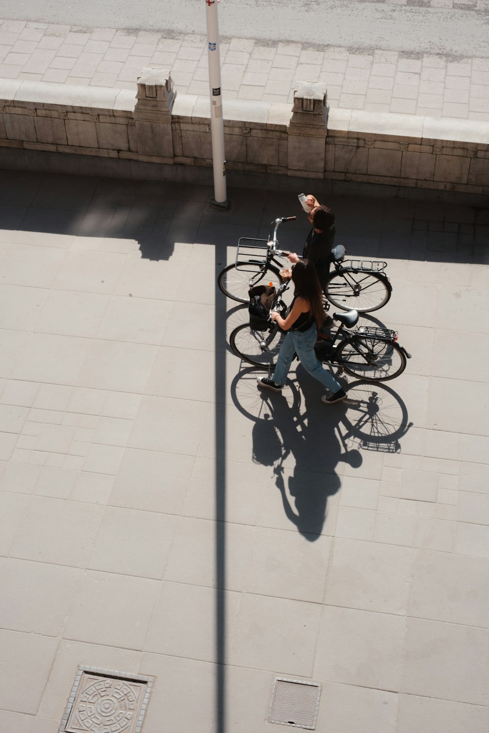 a man riding a bike down a street next to a sidewalk