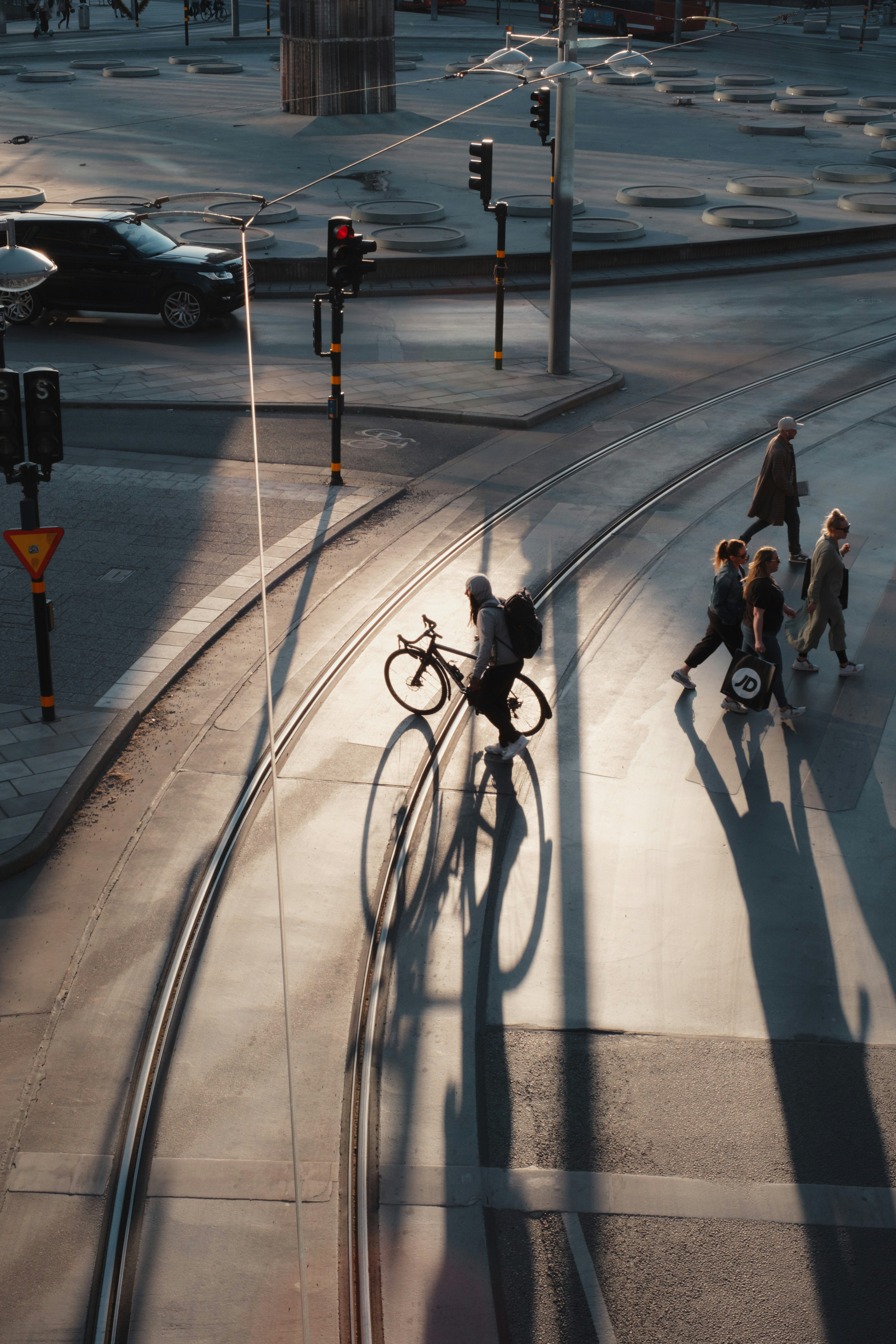 a man riding a bike down a street next to a traffic light