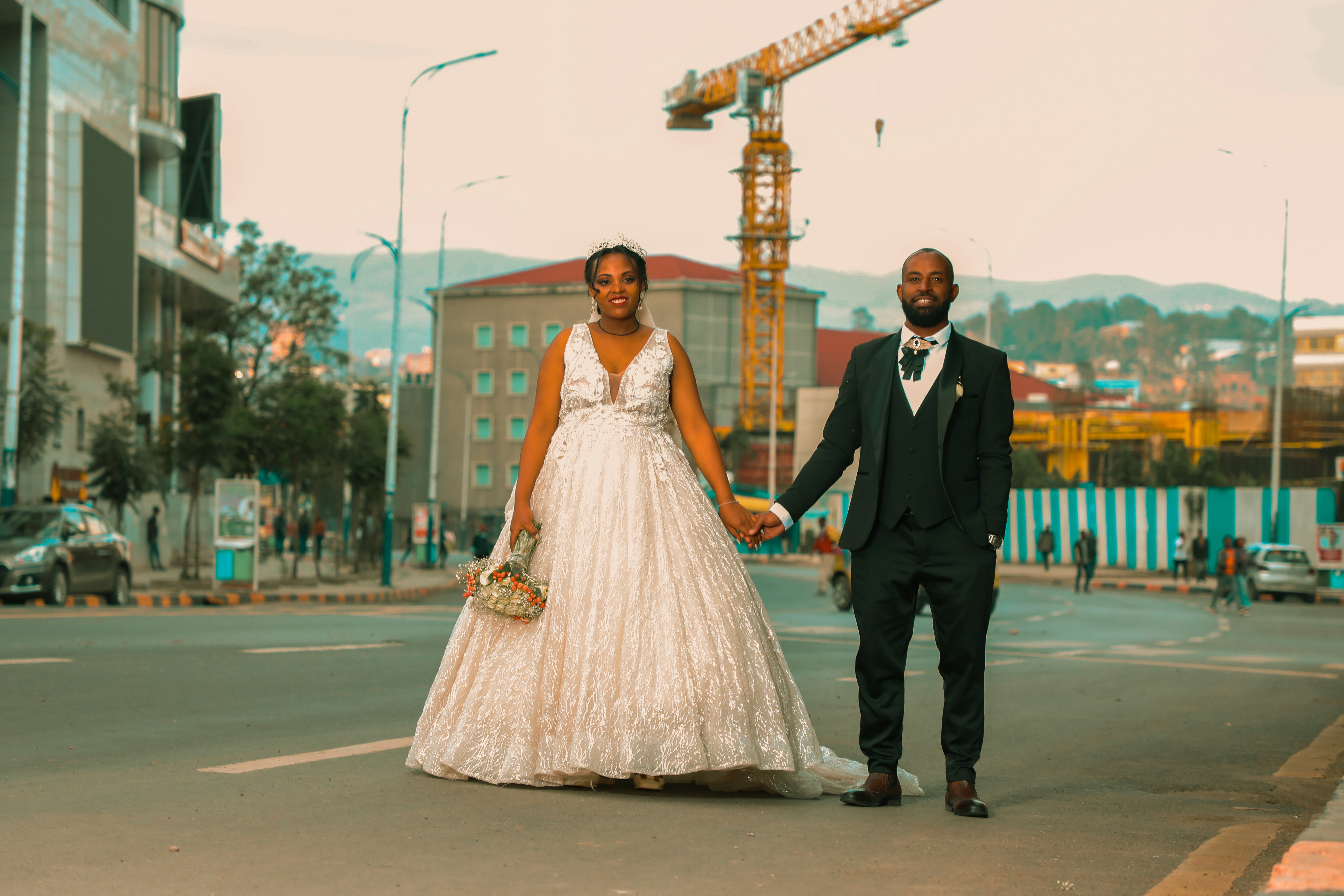 A bride and groom walking down the street holding hands photo – Free ...