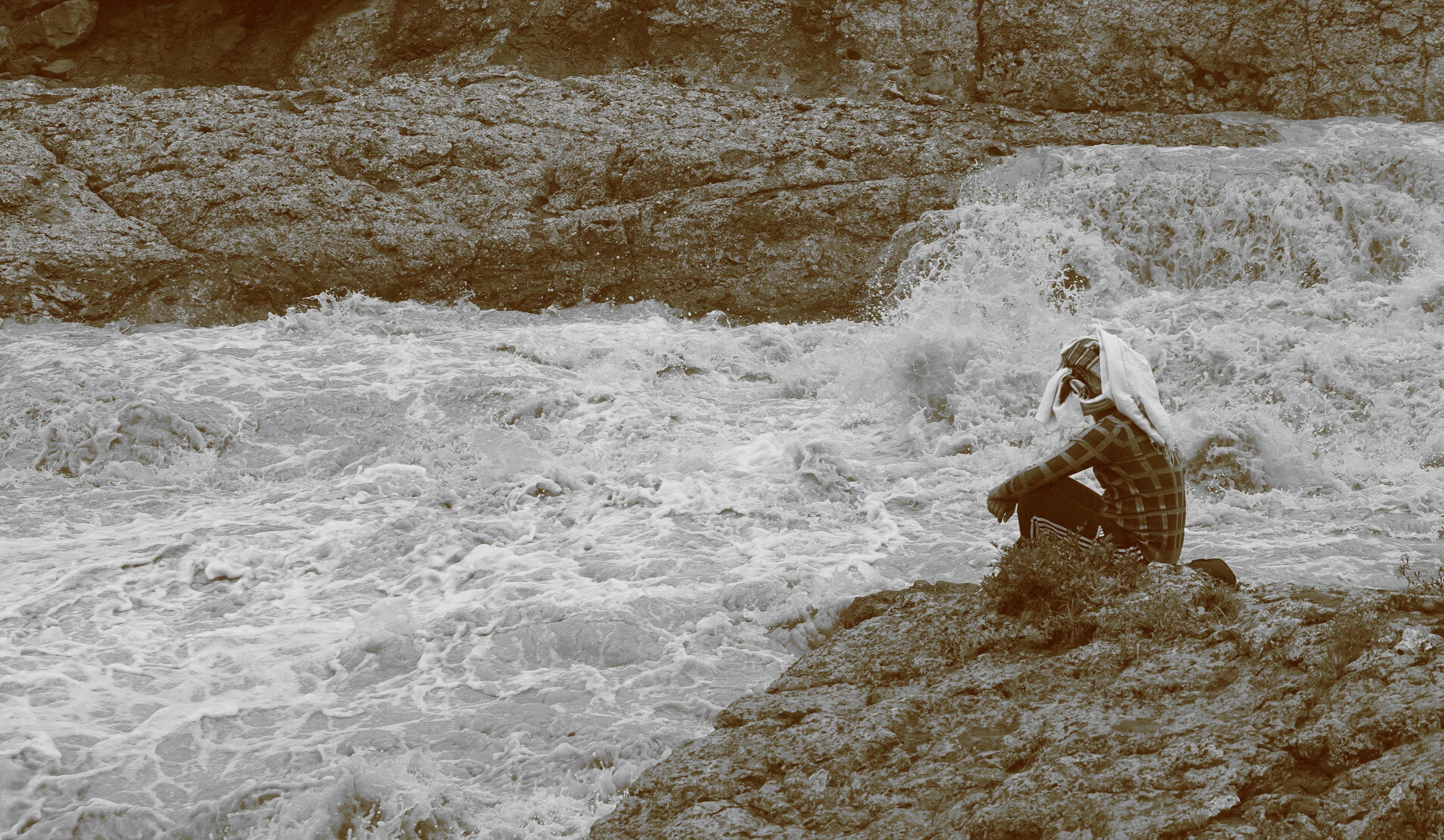 a woman sitting on a rock in front of a river
