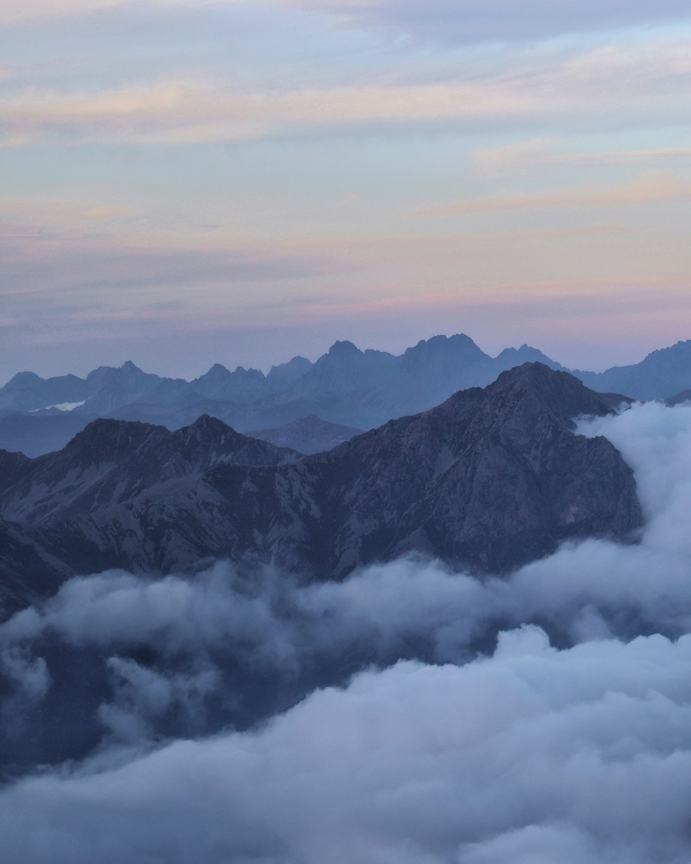 a view of a mountain range covered in clouds