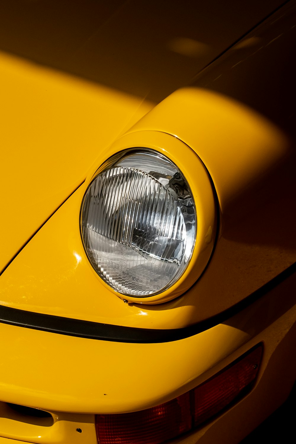a close up of a yellow car's headlight