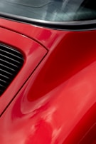 A close-up of a car being painted with a glossy finish.