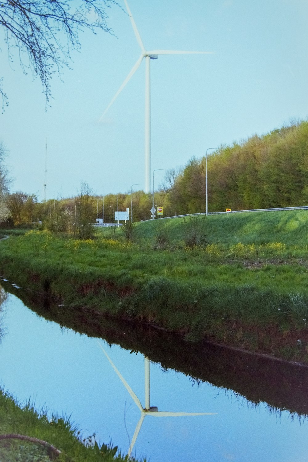 a windmill on a hill next to a river