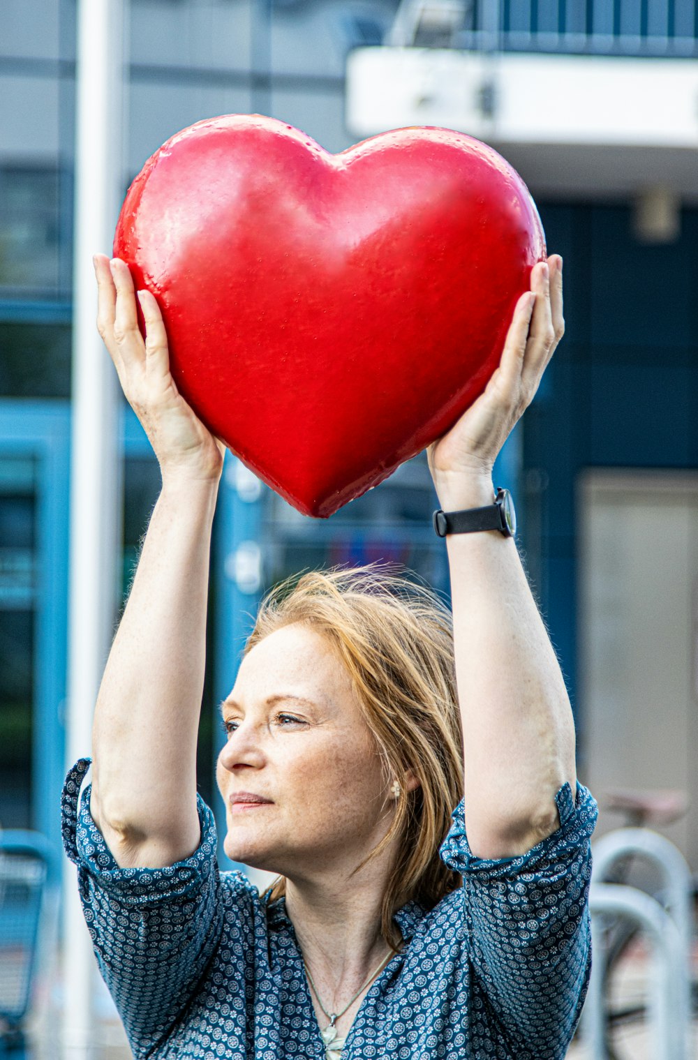 a woman holding a red heart shaped object
