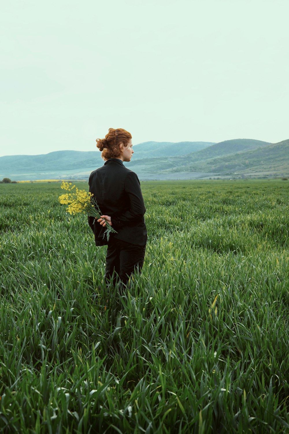 Eine Frau, die auf einem Feld mit hohem Gras steht