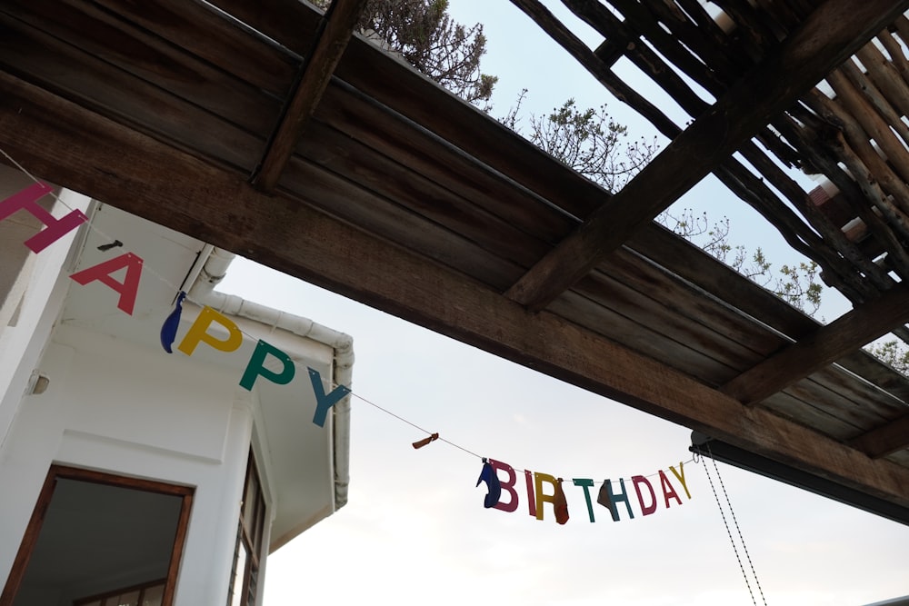 a happy birthday banner hanging from a wooden structure