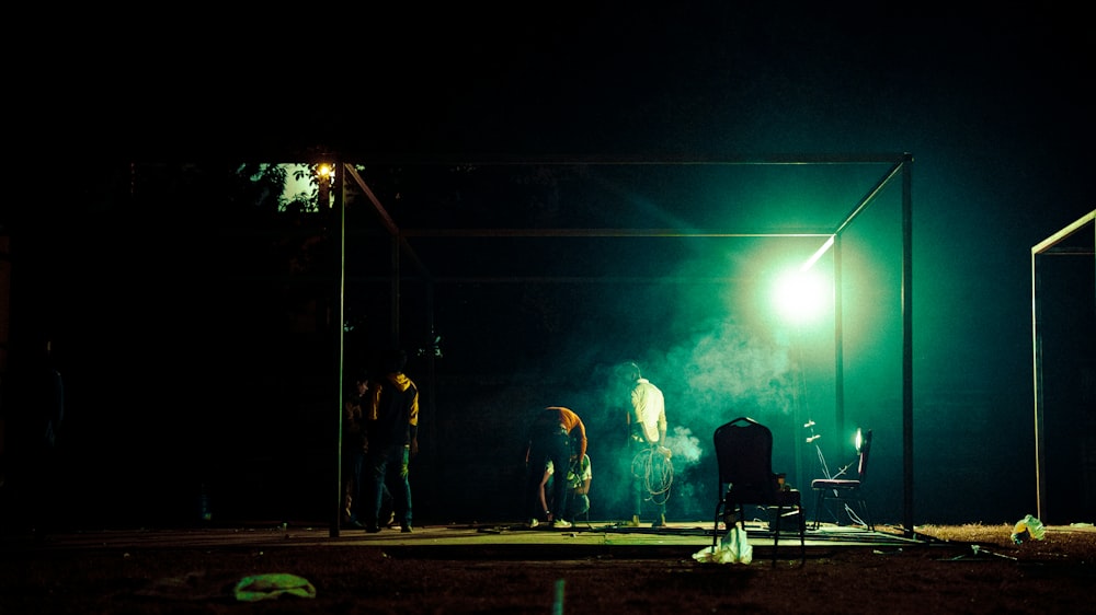 a group of people standing around a green light