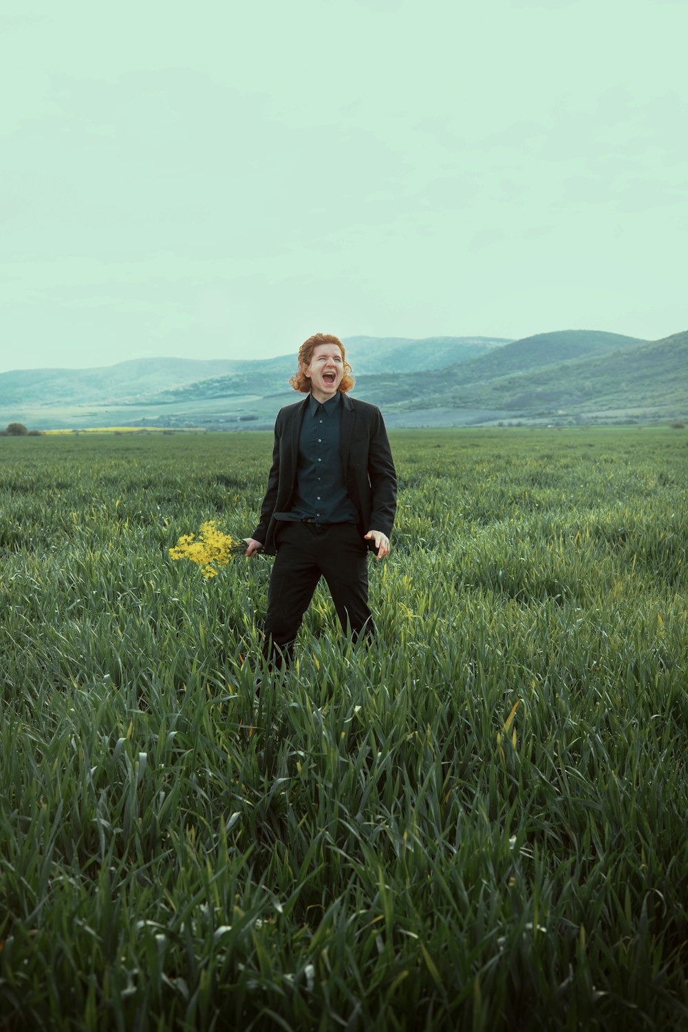 a woman standing in a field of tall grass