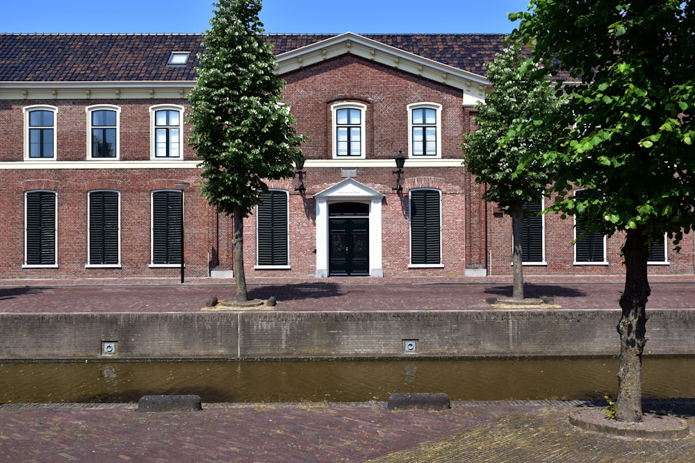 a large brick building with three trees in front of it