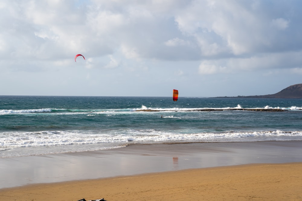 a couple of kites flying over the ocean