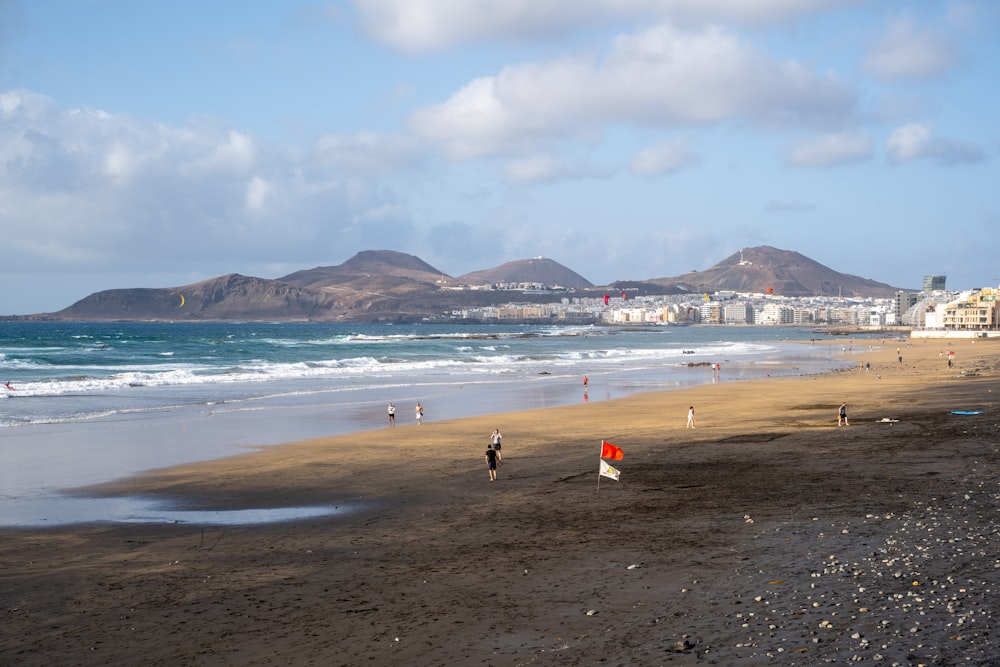 a group of people standing on top of a sandy beach