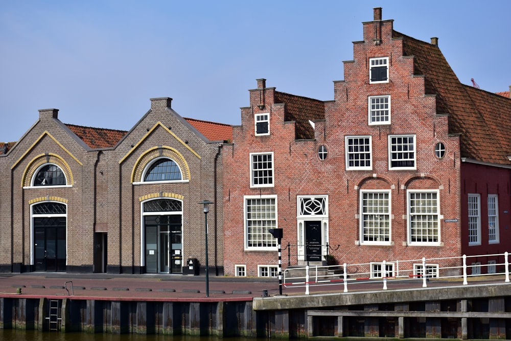 a row of brick buildings next to a body of water